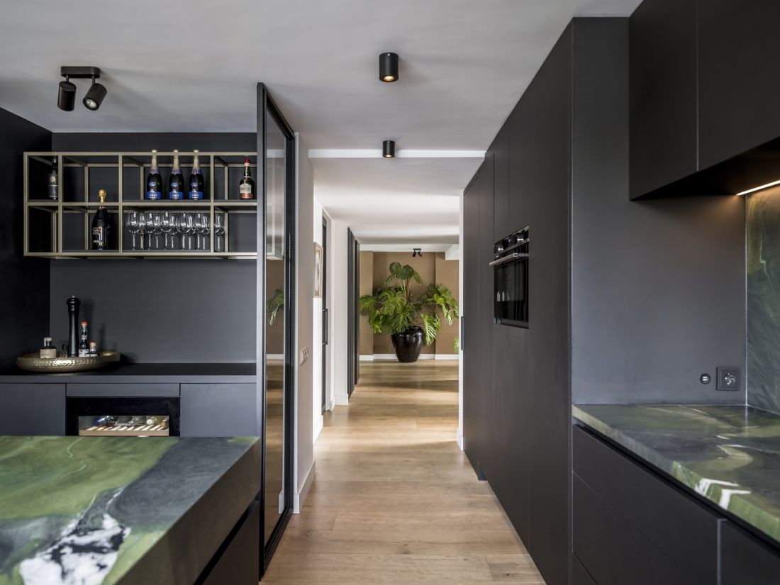 Zwarte keuken, keuken op maat, luxe keuken, maatwerk keuken, zwarte keukenkast, groen keukenblad, kookeiland, wijnrek, wijnkast, wijnkoeler