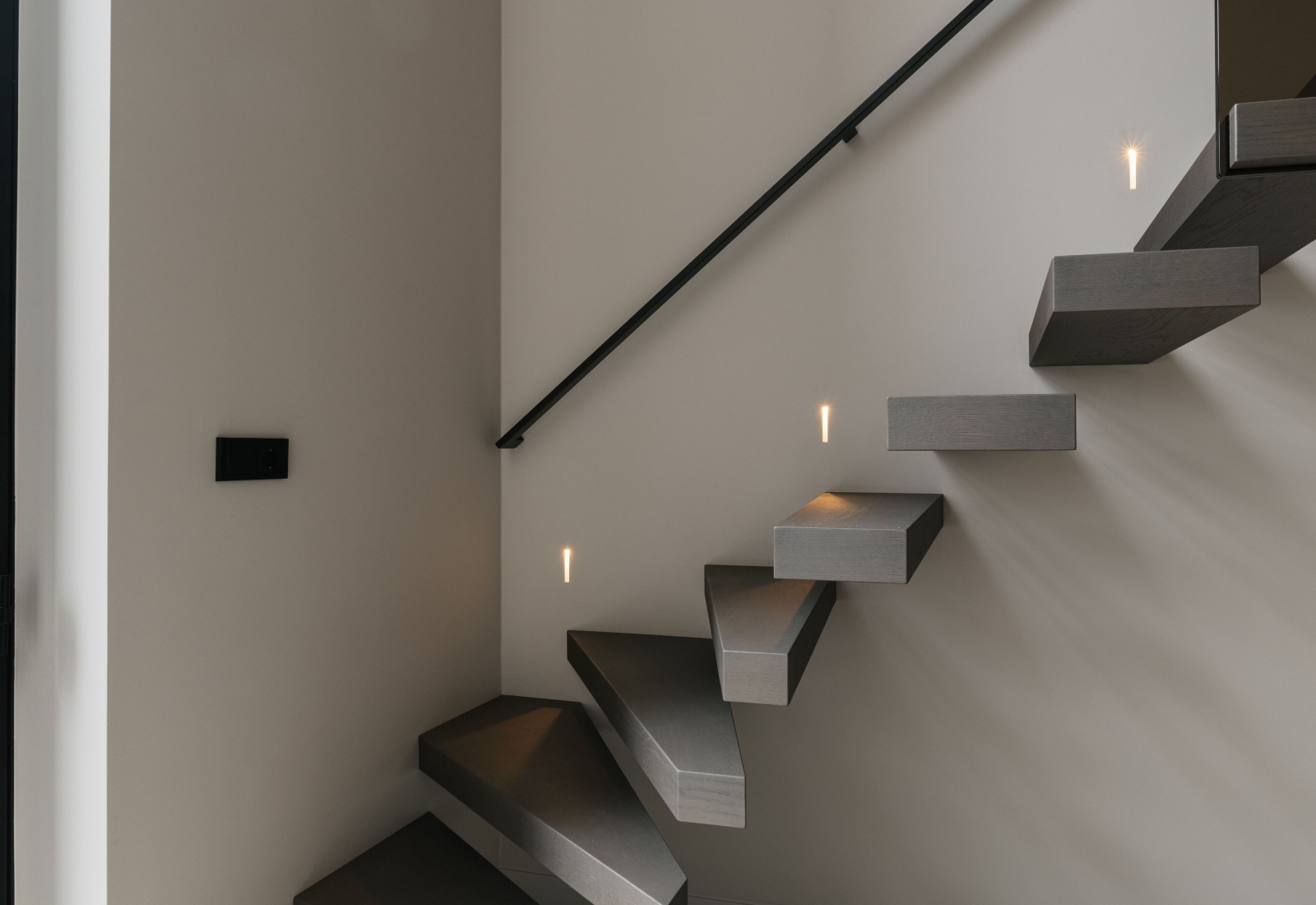 Zwevende trap met glazen trapleuning en verlichting