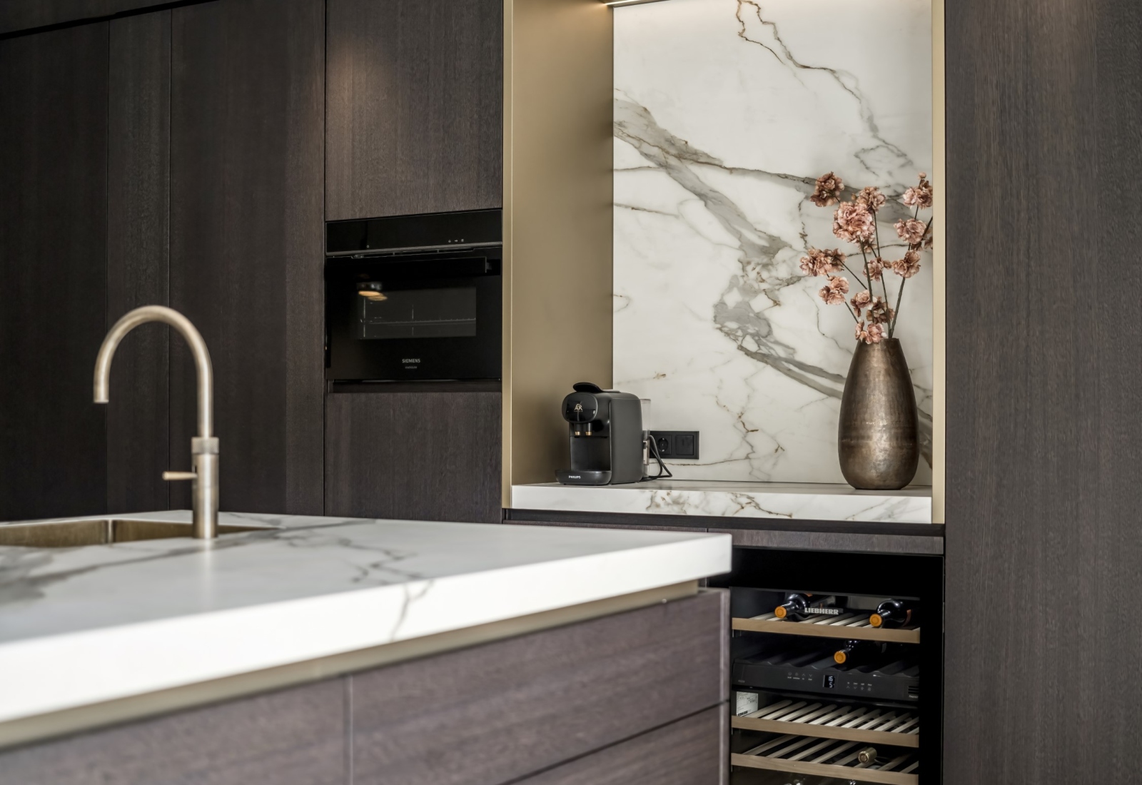 Luxe keuken, strakk interieurbouw, exclusieve keuken, koffienis, koffiehoek, kookeiland, keramisch keukenblad, bronzen accenten