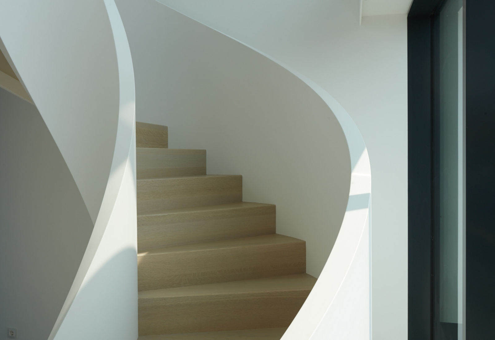 Witte wenteltrap met licht houten traptreden