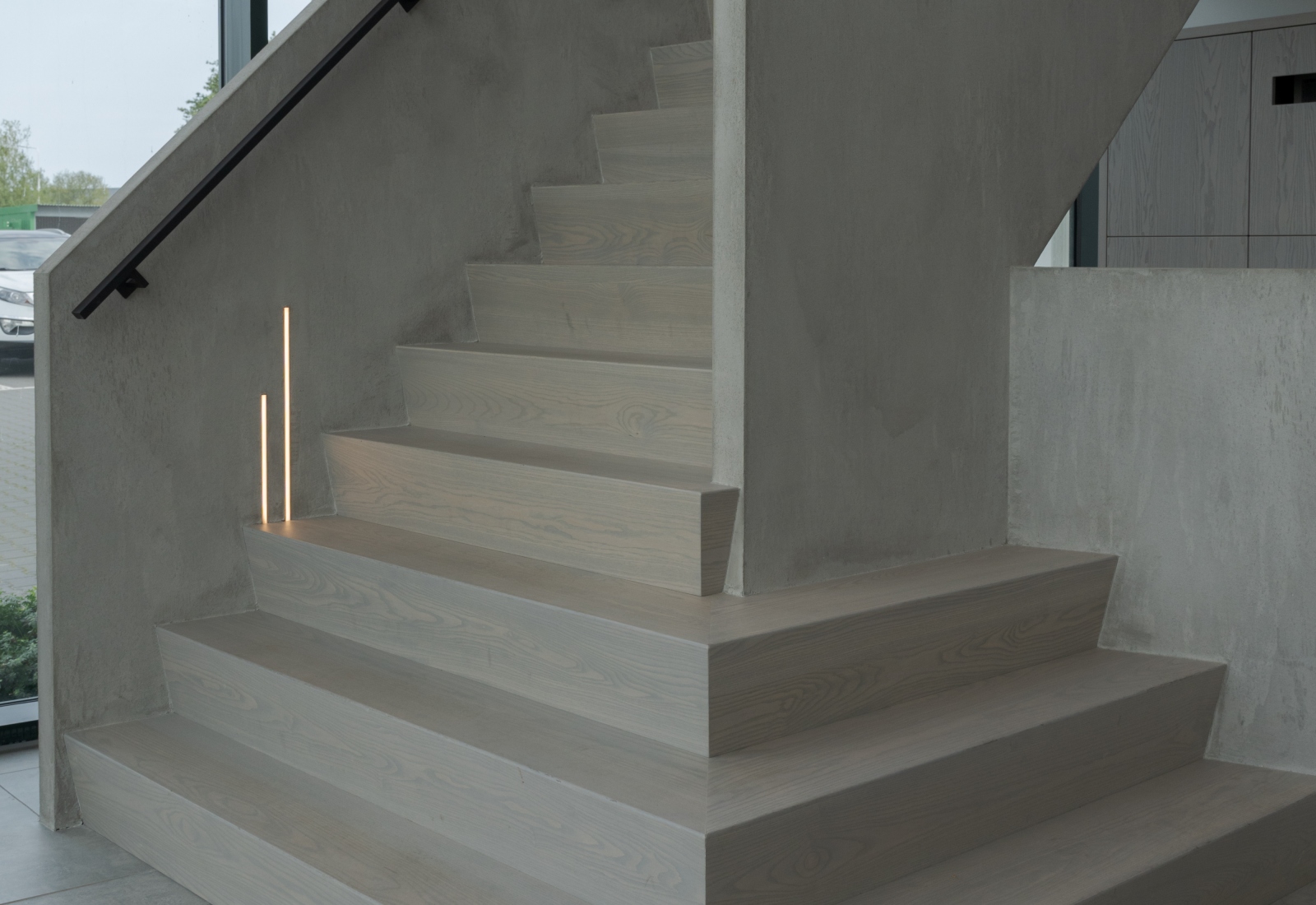Houten z-trap met betonlook leuning en verwerkte trapverlichting