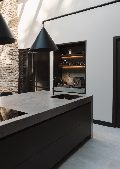 Zwarte maatwerk keuken met industriële look, koffienis, koffiehoek, kookeiland, strakk interieurbouw