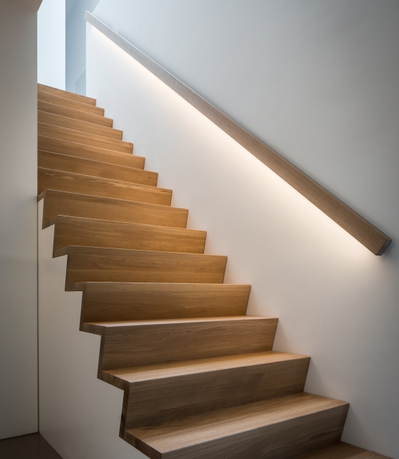 Houten z-trap met verlichtte trapleuning